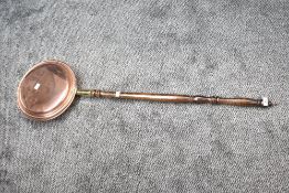A 20th century English polished copper bed warming pan, 105cm