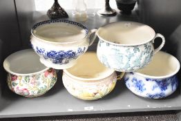 A selection of four early 20th century chamber pots decorated with foliage, 23cm.