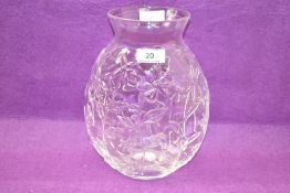 A decorative moulded glass vase having a short flared neck over an ovoid body moulded with