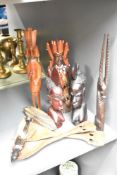 An African carved hardwood study of a warrior with weapons and shield, measuring 32cm high, together