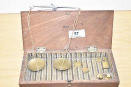 A set of 19th Century apothecary scales and weights, displayed within a mahogany hinged box