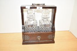 A quality 20th century solid mahogany two-bottled crystal Tantalus with sherry and gin label stamped