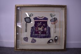 A Chinese framed children's embroidered silk waistcoat and accessories, comprising two tassled
