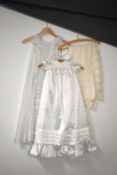 A Victorian christening dress in white cotton, a vintage childs gown and bonnet in satin, and a