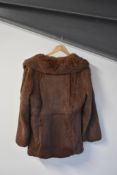A 20th century vintage coney (rabbit) fur coat, in a rich red-brown, having wide notched lapels,