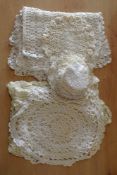 A collection of 20th century crochet doilies, in shades of off-white, having various knot