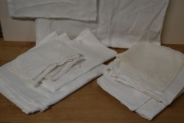 A quantity of vintage white cotton table cloths, place settings and furniture protectors,