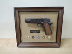 A Franklin Mint John Wayne Armed Forces Commemorative Replica .45 Automatic Hand Gun in framed