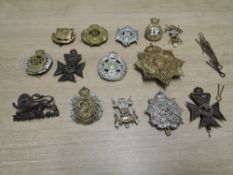 A collection of 14 Military Cap Badges including Kings Own, Border Regiment, Gibraltar, Kings