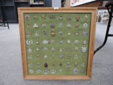 A framed display of Military Cap Badges including Argyll and Sutherland, The Welsh, The West Riding,
