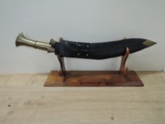 A large Kukri Knife having brass handle with two smaller knifes, blade length 46cm, overall length