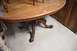 A Victorian mahogany loo table of oval form having tilt top, on turned column and quadruple scroll