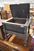 An early 20th Century oak stool on style frame having hinged lid storage