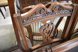 A pair of Victorian oak dining chairs having overstuffed seats and turned legs