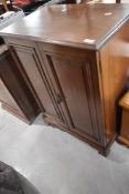 A late 19th or early 20th Century mahogany side cabinet having panelled doors and shelved