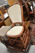 A Victorian mahogany rocking chair with later upholstery