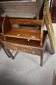 A vintage mahogany book trough and an early 20th Century oak occasional table/stool with drawer