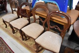 A set of four Victorian mahogany balloon back chairs having later cream upholstery