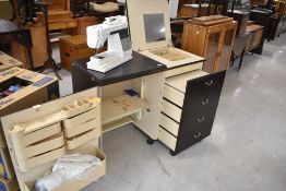 A vintage sewing cabinet having Elna Sewing machine, and various accesories