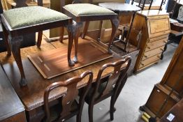 An early to mid 20th Century walnut extending dining table, four chair and a similar side cabinet,