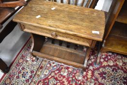 A vintage oak knitting table with frieze drawer and storage rack below , width approx. 55cm