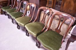 A set of six Victorian mahogany dining chairs having later dralon upholstered seats , on scroll