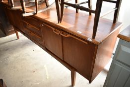 A 1970s teak sideboard of stylised design, width approx 206cm