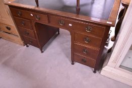 An early 20th Century mahogany desk having inset leather top and Regency style handles, width