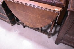 An early 20th Century gateleg dining table having oval top and barley twist frame
