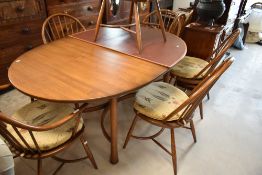A modern Ercol dining table and six (four plus two) hoop and stick back chairs having crinoline