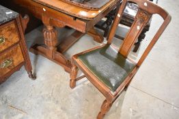 An early 20th Century oak drawer leaf table and set of four similar dining chairs