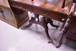 A 19th Century Regency design sofa table having beaded edge, two frieze drawers and drop flaps, over