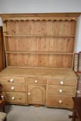 A 19th century pine dresser base, having ceramic handles and later complimentary plate rack, width