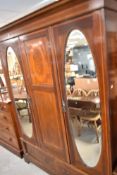 An early 20th century inlaid mahogany mirror door wardrobe, with moulded and inlaid cornice over the