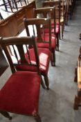 A set of four Victorian oak dining chairs having rail and spindle back, over stuffed seats on turned