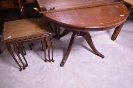 A reproduction oak nest of three tables, with tooled leather surface, sold together with a