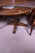 A late 20th century oak draw-out dining table, of circular form with concealed folding central leaf,