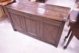An 18th century oak three panel coffer, of hinged rectangular form, the moulded plank top opening to