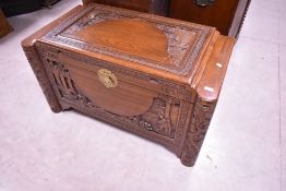A traditional Oriental Camphorwood blanket box having typical carved decoration, width approx.