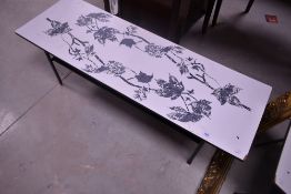 A vintage formica topped coffee table having metal frame and printed leaf design, approx. 115 x