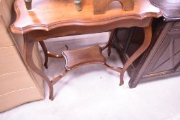 An Edwardian mahogany occasional table of moulded and shaped rectangular form with shaped and
