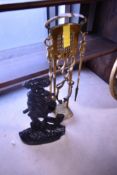 A vintage brass companion set and a cast door stop, modelled as woodsman with dog