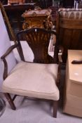 A reproduction mahogany armchair, of Georgian design with pierced central splat, shaped arms and