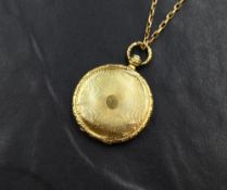 A 19th century yellow metal presumed gold hair locket, of circular form having engine turned