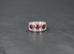 An 18ct white gold ruby and diamond open band ring, having three central rubies, total approximately