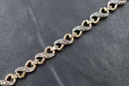 A 9ct gold diamond infinity motif bracelet, the infinity style links interspersed with round cut