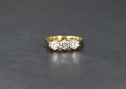 An 18ct gold diamond trilogy ring, the three round brilliant cut diamonds measuring approximately