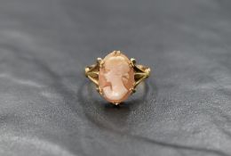 A 9ct gold cameo ring depicting a maiden in profile panel in claw set mount to split shoulders, size