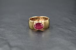 A gent's 9ct gold band ring having added oval ruby in a collared mount, approx 1.5ct, size V &