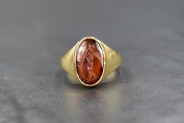 An 18ct gold carnelian intaglio ring, the oval Roman intaglio depicting an unusual version of the